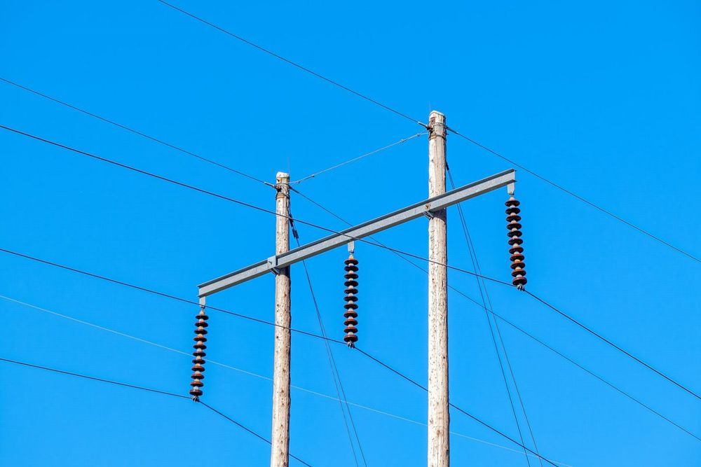 Postes de hormigón con aisladores y cables de media tensión
